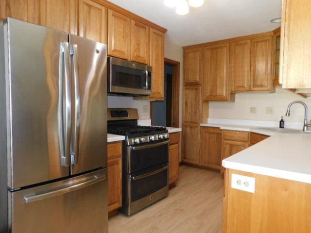 711 Glendale Ave, Rockford, IL 61108 - kitchen featuring appliances with stainless steel finishes, light countertops, light wood-style flooring, and brown cabinetry