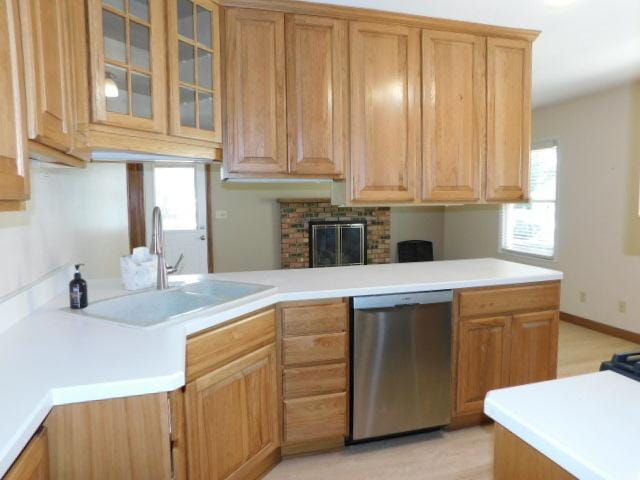 711 Glendale Ave, Rockford, IL 61108 - kitchen featuring stainless steel dishwasher, glass insert cabinets, light countertops, and a brick fireplace
