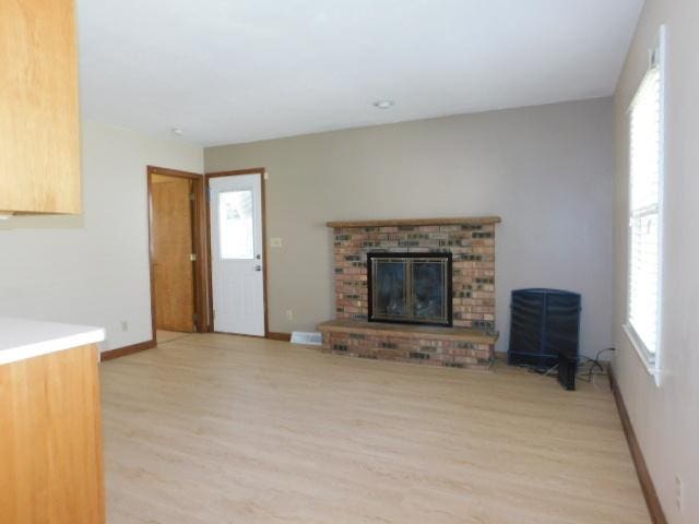 711 Glendale Ave, Rockford, IL 61108 - unfurnished living room featuring light wood finished floors and a fireplace