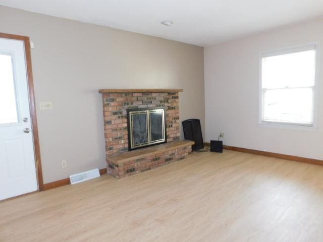 711 Glendale Ave, Rockford, IL 61108 - unfurnished living room with a brick fireplace and wood finished floors