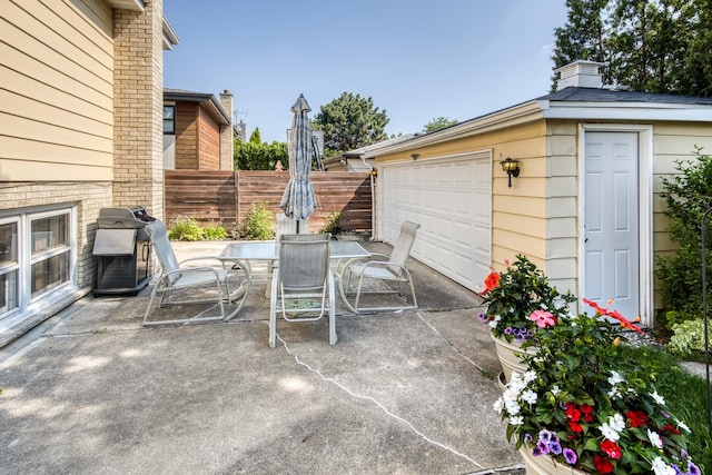 6955 N Dowagiac Ave, Chicago, IL 60646 - view of patio featuring a detached garage, outdoor dining area, and grilling area