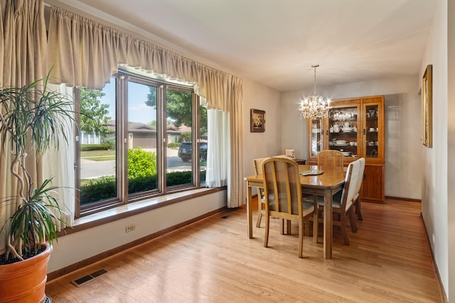 6955 N Dowagiac Ave, Chicago, IL 60646 - dining room featuring a chandelier and light wood-style floors