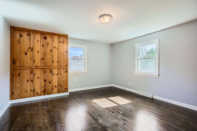 2630 Grunewald St, Blue Island, IL 60406 - empty room featuring plenty of natural light, wood finished floors, and a baseboard radiator