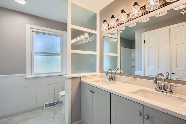 2630 Grunewald St, Blue Island, IL 60406 - full bath with marble finish floors, double vanity, tile walls, a wainscoted wall, and a shower