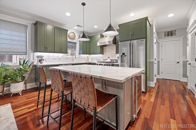 2340 W Roscoe St Unit 2W, Chicago, IL 60618 - kitchen with green cabinets, stainless steel appliances, wall chimney exhaust hood, crown molding, and tasteful backsplash