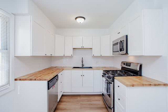 8909 N Washington St Unit E, Niles, IL 60714 - kitchen featuring appliances with stainless steel finishes, butcher block counters, and decorative backsplash