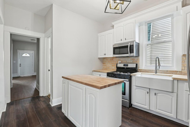 7959 S Saginaw Ave, Chicago, IL 60617 - kitchen with stainless steel appliances, wooden counters, decorative backsplash, dark wood finished floors, and white cabinets