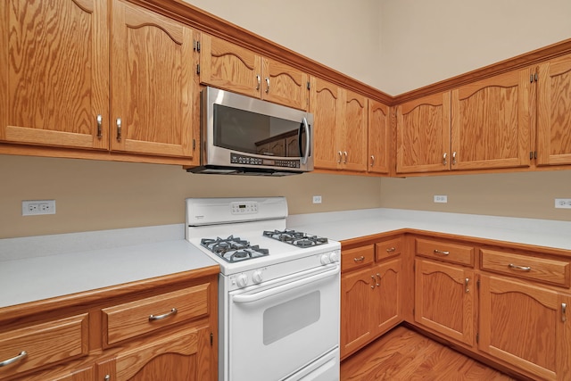 1824 Mia Dr, Crest Hill, IL 60403 - kitchen featuring stainless steel microwave, white gas range oven, light countertops, and light wood-style floors