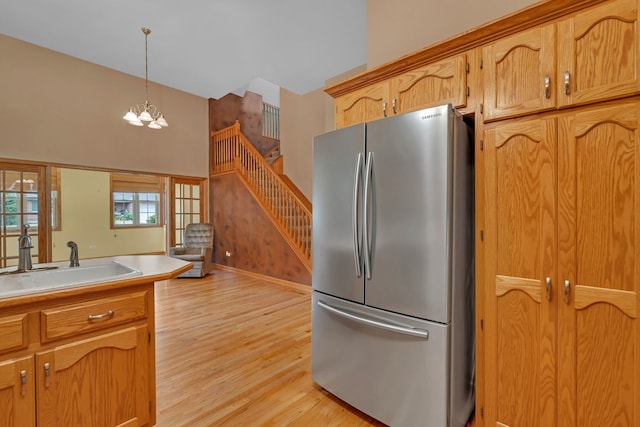 1824 Mia Dr, Crest Hill, IL 60403 - kitchen featuring freestanding refrigerator, a towering ceiling, light wood-type flooring, pendant lighting, and a chandelier