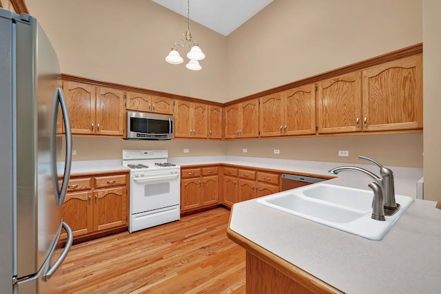 1824 Mia Dr, Crest Hill, IL 60403 - kitchen featuring appliances with stainless steel finishes, light wood finished floors, a chandelier, decorative light fixtures, and brown cabinetry