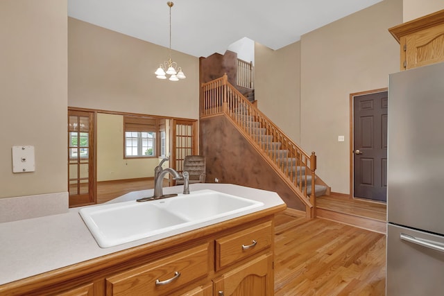 1824 Mia Dr, Crest Hill, IL 60403 - kitchen featuring stainless steel fridge, a towering ceiling, decorative light fixtures, light wood-style floors, and a chandelier
