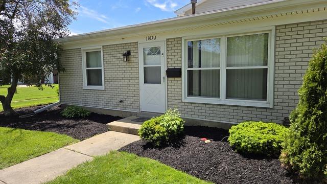 1303 Kingsbury Dr Unit A, Hanover Park, IL 60133 - entrance to property with brick siding and a yard