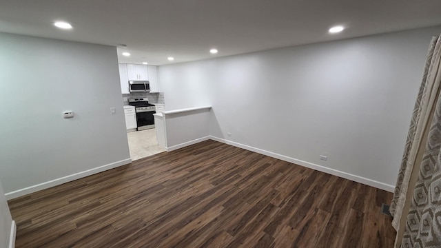 1303 Kingsbury Dr Unit A, Hanover Park, IL 60133 - interior space with stainless steel appliances, dark wood finished floors, decorative backsplash, recessed lighting, and white cabinetry