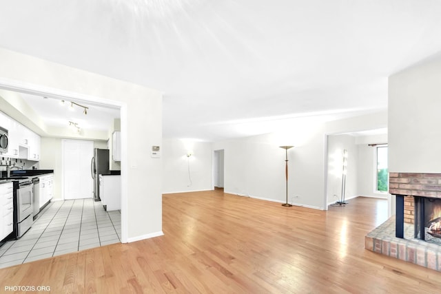 1621 Mission Hills Rd Unit 510, Northbrook, IL 60062 - unfurnished living room featuring track lighting, light wood finished floors, and a fireplace