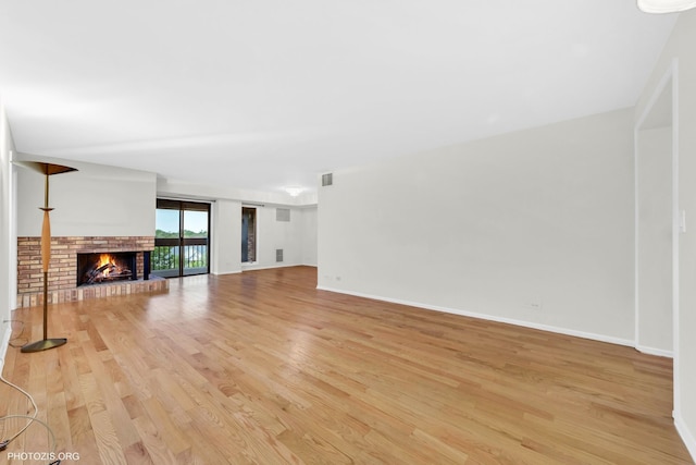 1621 Mission Hills Rd Unit 510, Northbrook, IL 60062 - unfurnished living room featuring light wood-style floors and a brick fireplace