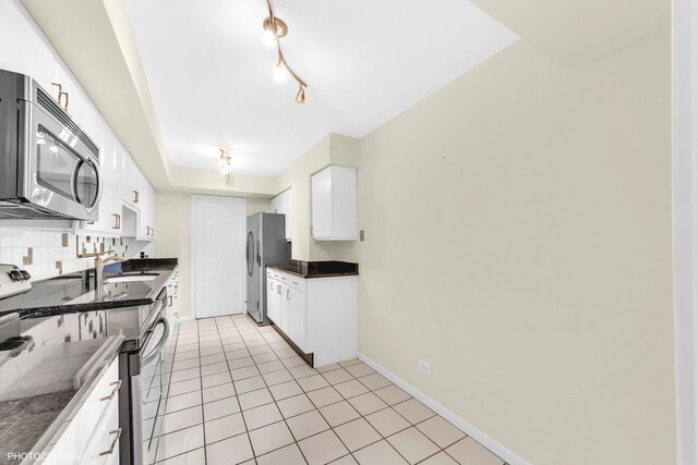 1621 Mission Hills Rd Unit 510, Northbrook, IL 60062 - kitchen with appliances with stainless steel finishes, white cabinets, light tile patterned flooring, and decorative backsplash