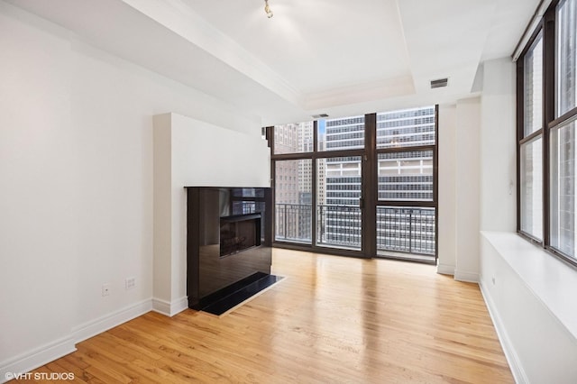 212 W Washington St Unit 1112, Chicago, IL 60606 - unfurnished living room with healthy amount of natural light, a raised ceiling, wood finished floors, expansive windows, and a multi sided fireplace