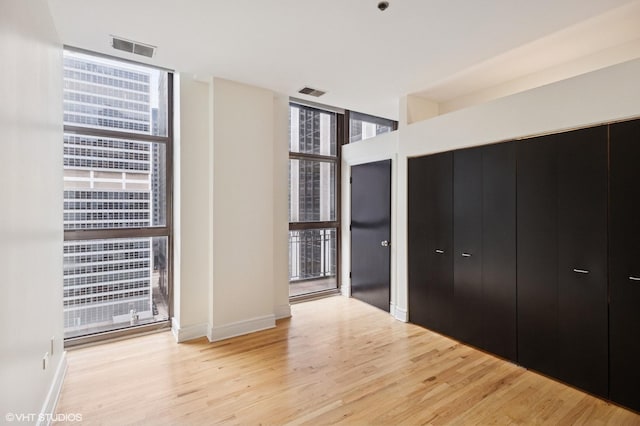 212 W Washington St Unit 1112, Chicago, IL 60606 - unfurnished bedroom featuring floor to ceiling windows and wood finished floors