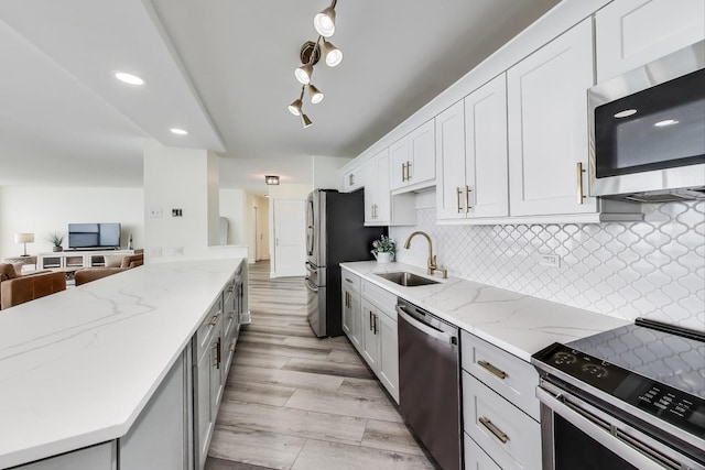 940 W Glenlake Ave Unit 19C, Chicago, IL 60660 - kitchen featuring stainless steel appliances, light stone countertops, decorative backsplash, white cabinetry, and open floor plan