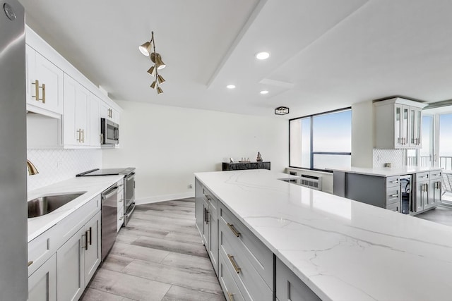 940 W Glenlake Ave Unit 19C, Chicago, IL 60660 - kitchen featuring appliances with stainless steel finishes, recessed lighting, decorative backsplash, light stone countertops, and gray cabinets