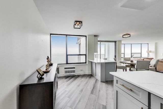 940 W Glenlake Ave Unit 19C, Chicago, IL 60660 - kitchen with open floor plan, light wood-type flooring, an AC wall unit, and light stone countertops