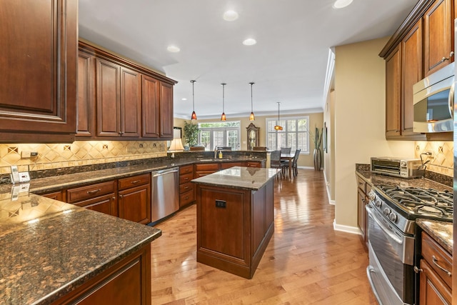 9 Aztec Ct, South Barrington, IL 60010 - kitchen featuring appliances with stainless steel finishes, a peninsula, decorative backsplash, light wood-type flooring, and recessed lighting