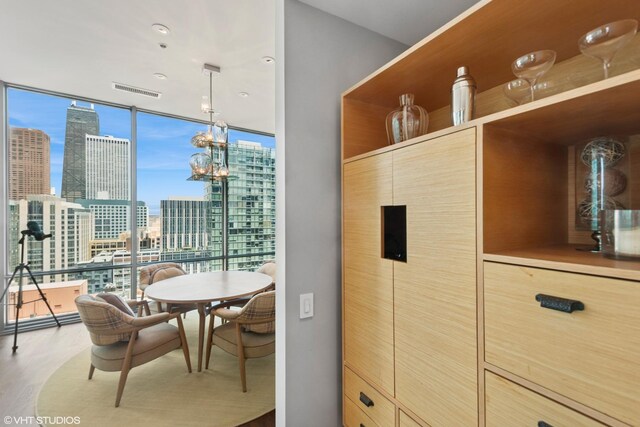 240 E Illinois St Unit 2702, Chicago, IL 60611 - kitchen featuring a view of skyline, light brown cabinetry, wood finished floors, and a wall of windows