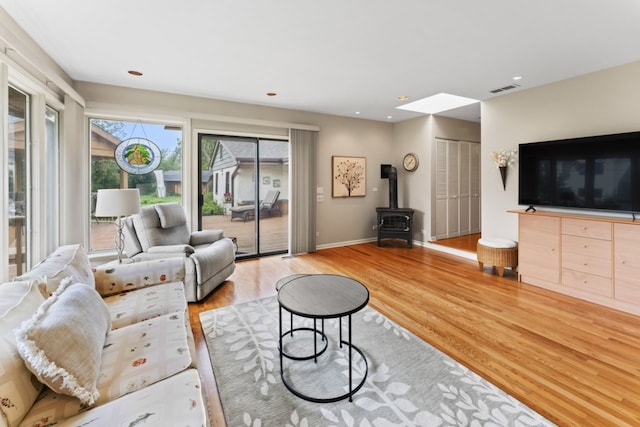 216 Hickory Ct, Northbrook, IL 60062 - living room featuring a wood stove, wood finished floors, a skylight, and recessed lighting