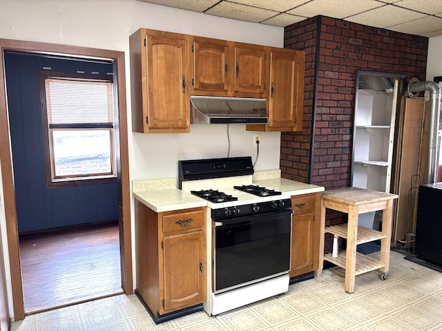 2838 S Keeley St, Chicago, IL 60608 - kitchen with range with gas stovetop, range hood, a drop ceiling, light countertops, and light floors