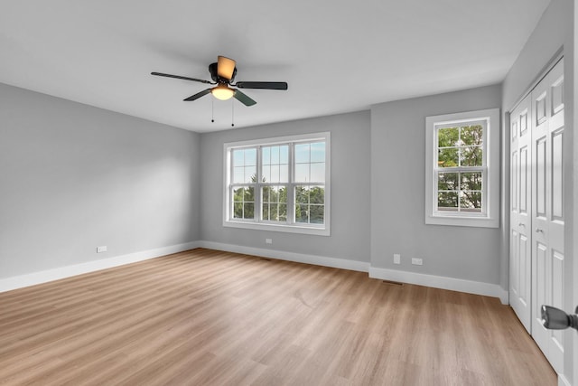 24642 George Washington Dr, Plainfield, IL 60544 - unfurnished bedroom with multiple windows, light wood-type flooring, a closet, and a ceiling fan