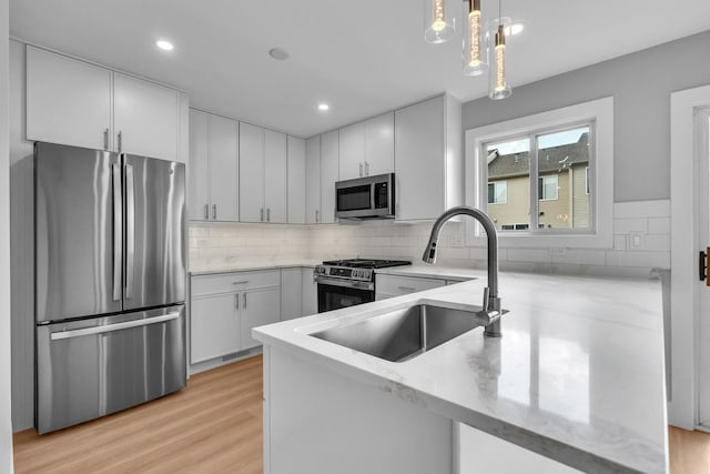 24642 George Washington Dr, Plainfield, IL 60544 - kitchen with stainless steel appliances, light stone counters, light wood-style flooring, backsplash, and recessed lighting