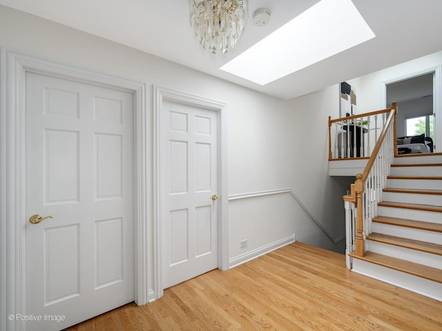 2612 Wilmette Ave, Wilmette, IL 60091 - stairway featuring a skylight, wood finished floors, and a chandelier