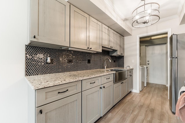 327 Georgetown Ct Unit B, Bloomingdale, IL 60108 - kitchen featuring freestanding refrigerator, ornamental molding, tasteful backsplash, washer and clothes dryer, and light wood-style flooring