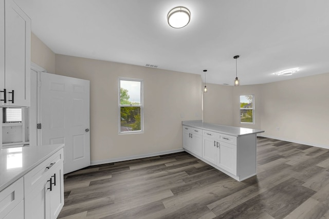 515 George Ave, Waukegan, IL 60085 - kitchen featuring a peninsula, dark wood-style floors, white cabinetry, and plenty of natural light
