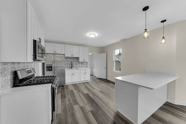 515 George Ave, Waukegan, IL 60085 - kitchen with appliances with stainless steel finishes, a peninsula, light wood finished floors, backsplash, and light countertops