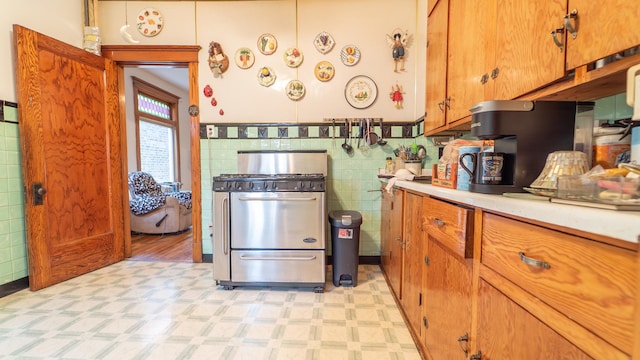 10747 S S Ave H, Chicago, IL 60617 - kitchen with light floors, stainless steel gas range oven, light countertops, brown cabinets, and tile walls