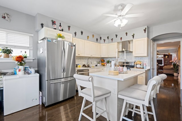 6921 26th St, Berwyn, IL 60402 - kitchen with appliances with stainless steel finishes, wall chimney range hood, a kitchen breakfast bar, dark wood-style floors, and light countertops