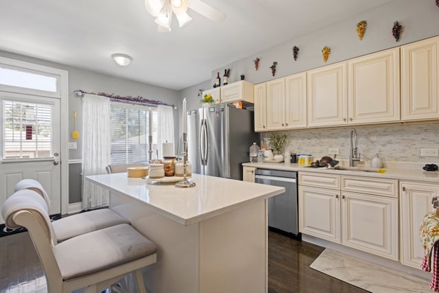 6921 26th St, Berwyn, IL 60402 - kitchen with appliances with stainless steel finishes, dark wood-style flooring, a breakfast bar area, a center island, and decorative backsplash