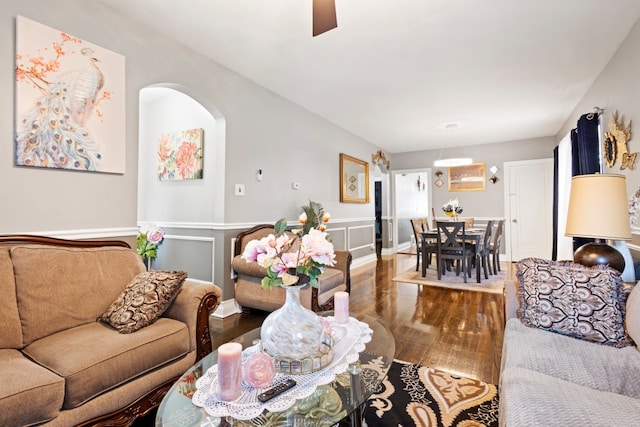 6921 26th St, Berwyn, IL 60402 - living room featuring wood finished floors, arched walkways, wainscoting, and ceiling fan