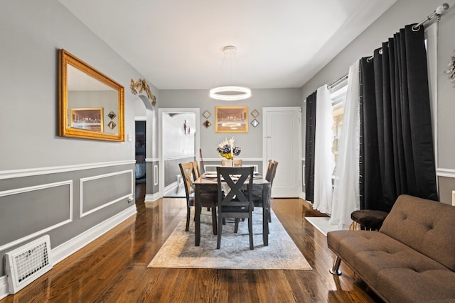 6921 26th St, Berwyn, IL 60402 - dining space featuring dark wood-style floors, a chandelier, and arched walkways
