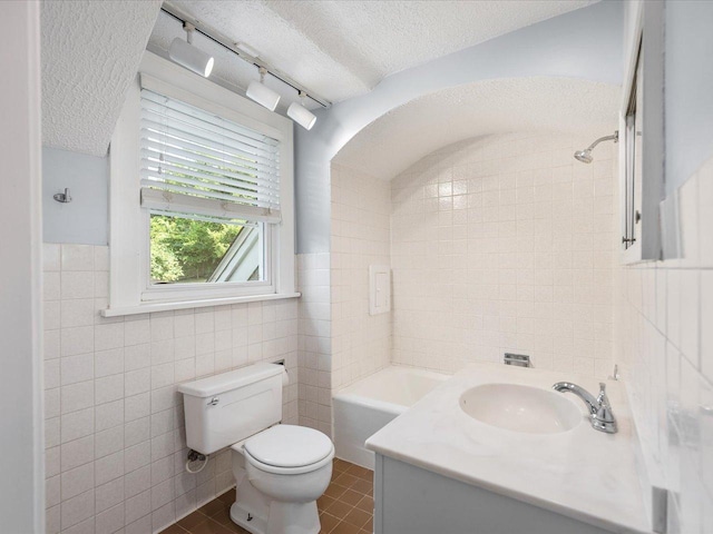 1639 Arlington Ave, Rockford, IL 61107 - bathroom featuring tile walls, a textured ceiling, vanity, tile patterned floors, and a bath