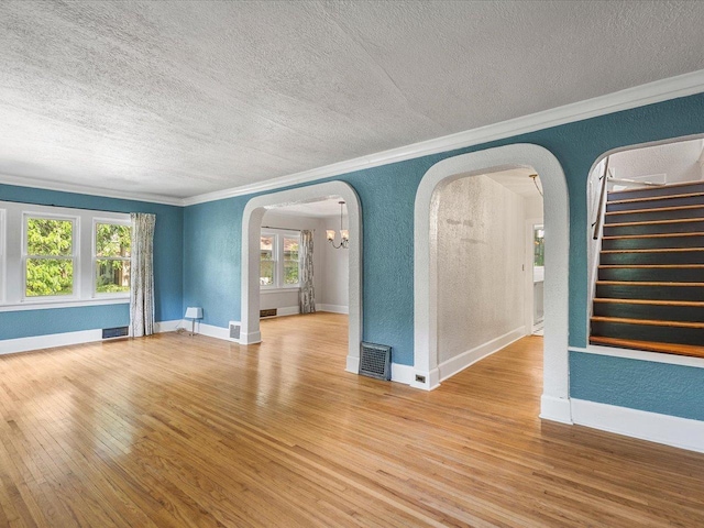 1639 Arlington Ave, Rockford, IL 61107 - unfurnished room featuring arched walkways, a textured ceiling, crown molding, a textured wall, and wood finished floors