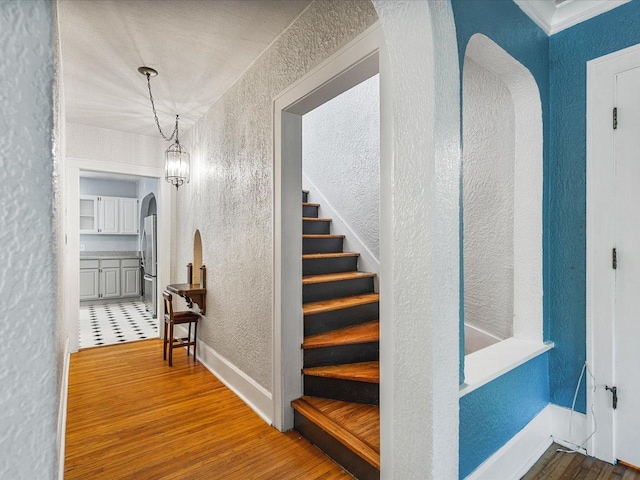1639 Arlington Ave, Rockford, IL 61107 - hallway with a textured wall, arched walkways, wood finished floors, and stairway