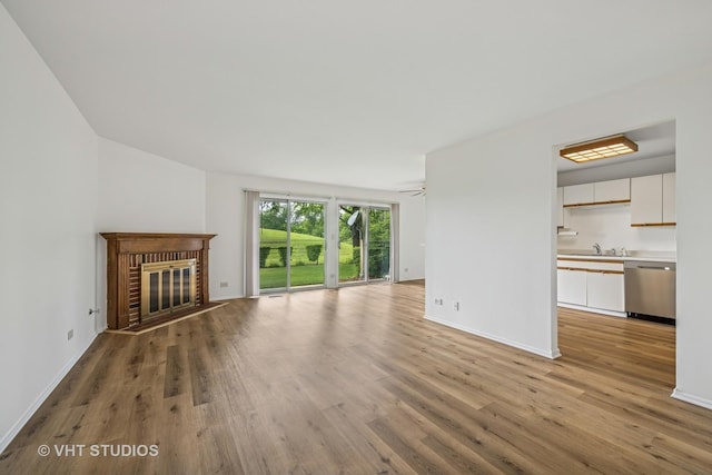 600 Hanover Ct Unit V1, Schaumburg, IL 60194 - unfurnished living room with light wood-style flooring and a brick fireplace