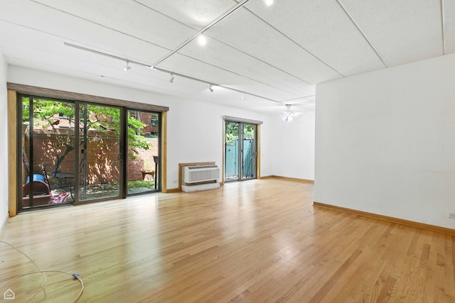 1121 S Plymouth Ct Unit A, Chicago, IL 60605 - unfurnished room with a wall unit AC, light wood finished floors, rail lighting, and a ceiling fan