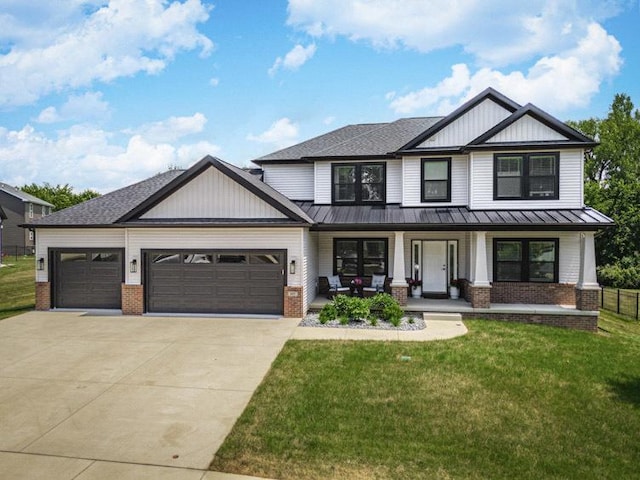 207 Eldon Dr, Downs, IL 61736 - view of front facade featuring brick siding, a standing seam roof, an attached garage, covered porch, and a front lawn