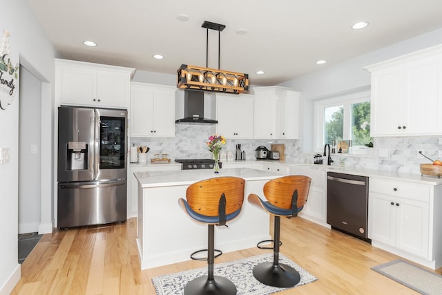 207 Eldon Dr, Downs, IL 61736 - kitchen featuring stainless steel appliances, wall chimney range hood, light countertops, a center island, and white cabinetry