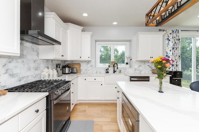 207 Eldon Dr, Downs, IL 61736 - kitchen with stainless steel appliances, wall chimney exhaust hood, light wood finished floors, white cabinetry, and recessed lighting