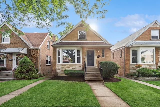 5406 N Mulligan Ave, Chicago, IL 60630 - view of front facade featuring a front yard, stone siding, and roof with shingles