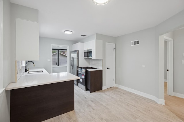 5406 N Mulligan Ave, Chicago, IL 60630 - kitchen featuring stainless steel appliances, light countertops, light wood-type flooring, and backsplash